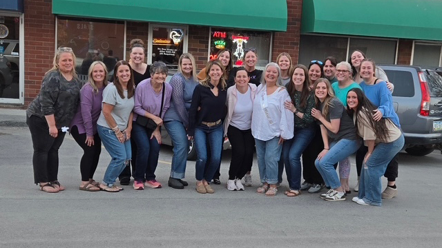Everyone from Norwalk Family Dentistry taking a group picture in front of a building with green awnings